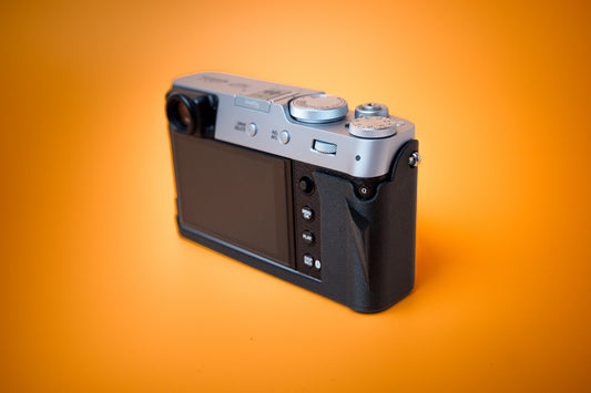 Fujifilm X100VI in black, rear right view, fitted with an Akara Labs Slim Skin standard case in black leatherette-textured TPU