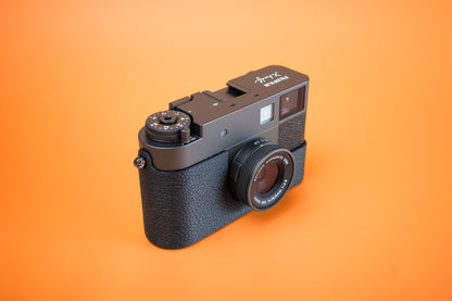 Fujifilm X half in a black TPU Slim Skin no grip Case, front three-quarter view