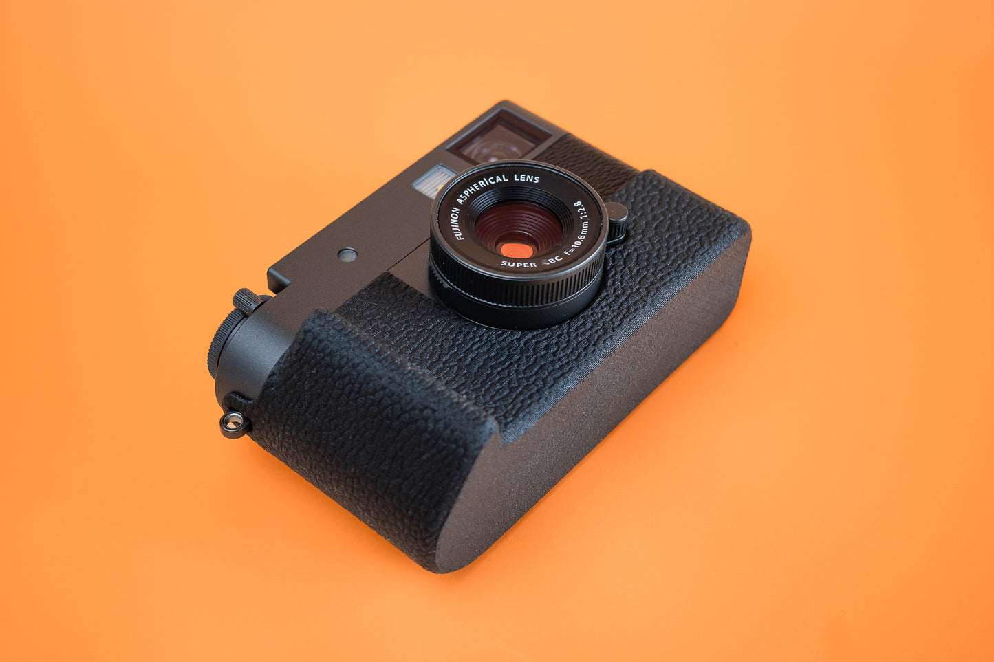 Fujifilm X half in Slim Skin Case with grip, angled view showing grip and base of case
