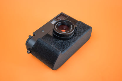 Fujifilm X half in Slim Skin Case with grip, angled view showing grip and base of case