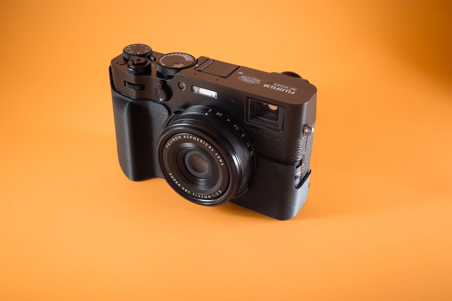 Fujifilm X100VI in black, front angled view, fitted with an Akara Labs Slim Skin standard case in black leatherette-textured TPU