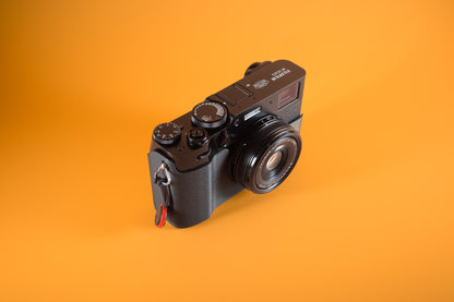 Fujifilm X100VI in black, front right view, fitted with an Akara Labs Slim Skin standard case in black leatherette-textured TPU