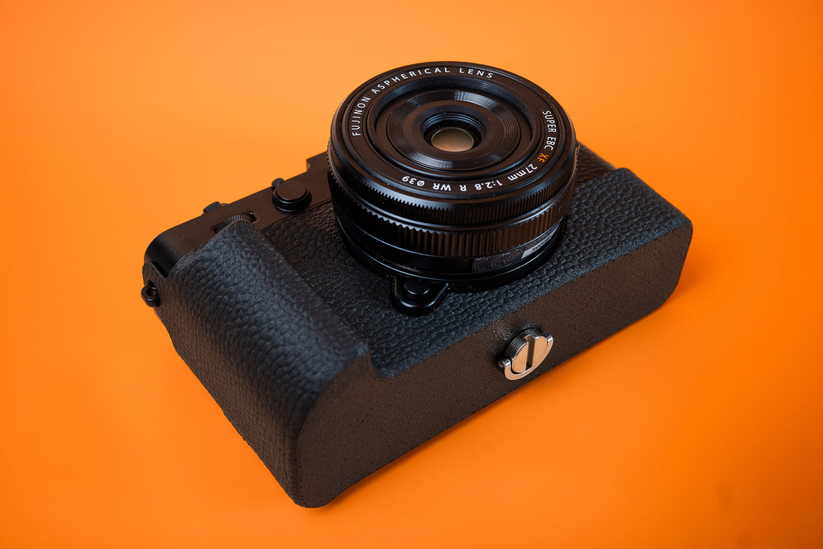 Fujifilm X-E5 in black, bottom view, fitted with an Akara Labs Slim Skin tripod version case in black leatherette-textured TPU