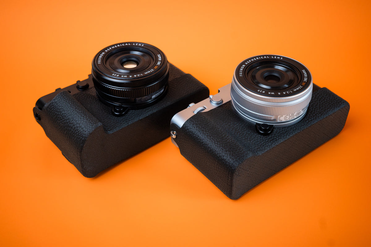 Fujifilm X-E5 in silver and black, bottom view, fitted with Akara Labs standard Slim Skin cases in black leatherette-textured TPU