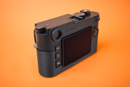 Leica M11 camera with Akara Labs Slim Skin Case. Rear left view. Orange background.