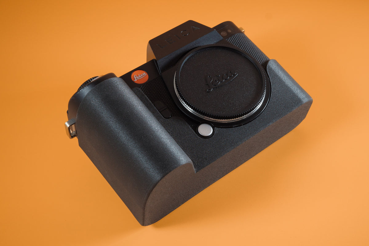 Leica SL2 in Akara Labs TPU Slim Skin camera case. Front right of camera. Orange background.