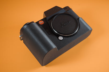 Leica SL2 in Akara Labs TPU Slim Skin camera case. Front right of camera. Orange background.