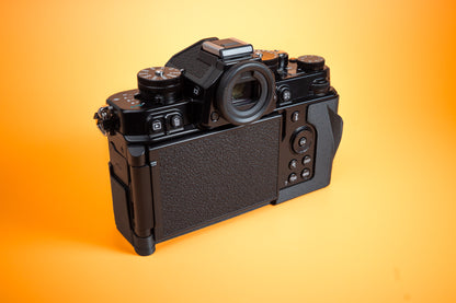 Nikon ZF TPU Slim Skin Case with thumb grip. Rear left view of camera. Orange background.
