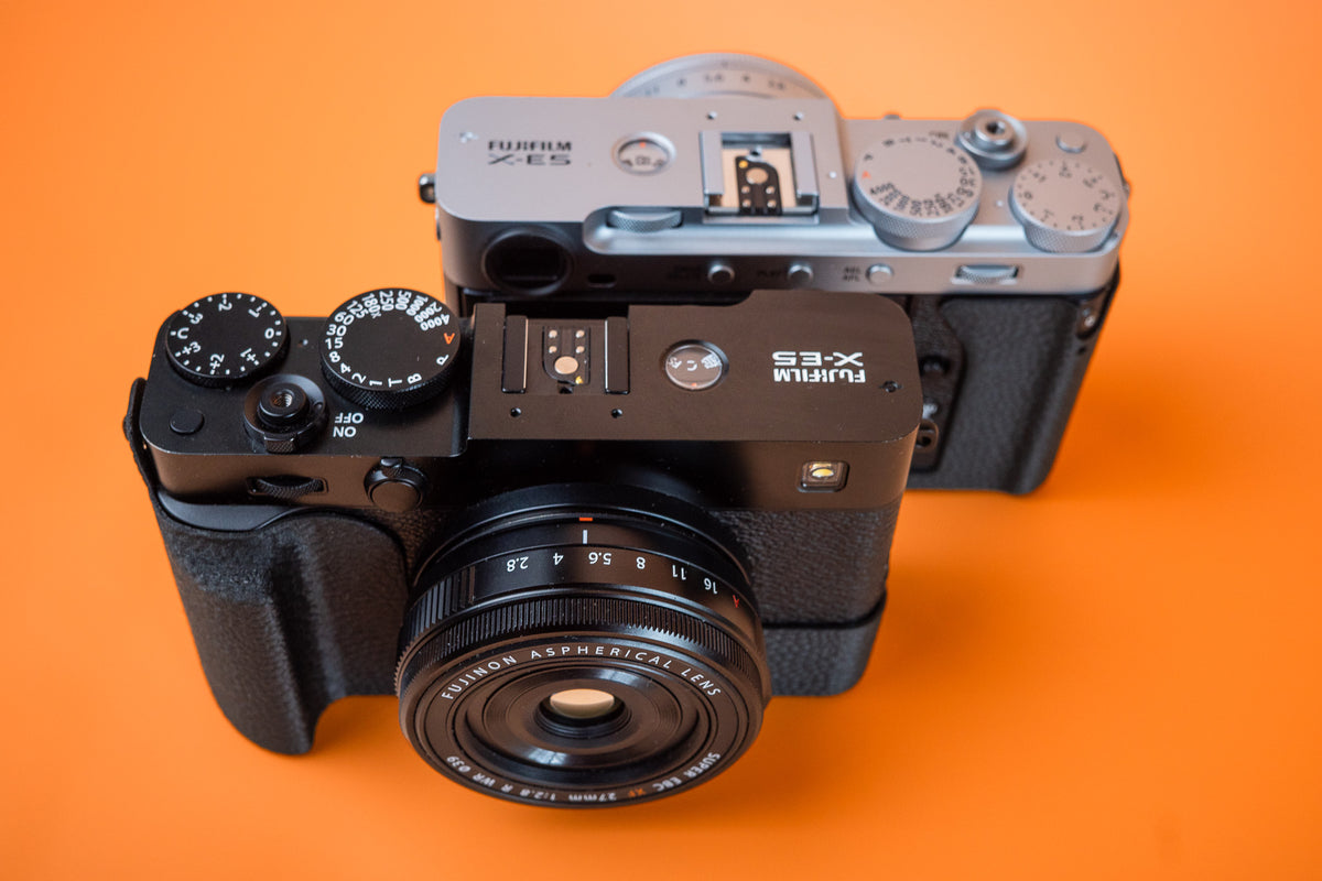 Fujifilm X-E5 in silver and black, black front view, fitted with an Akara Labs Slim Skin grip case in black leatherette-textured TPU